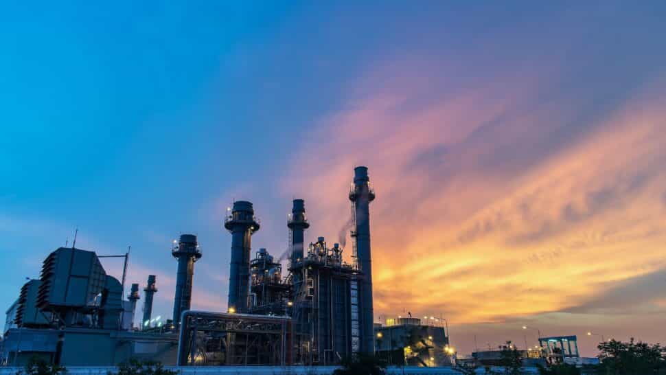 Industrial plant silhouette against a vibrant sunset sky.