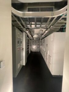 Industrial corridor with metal conduits and control panels in a power facility