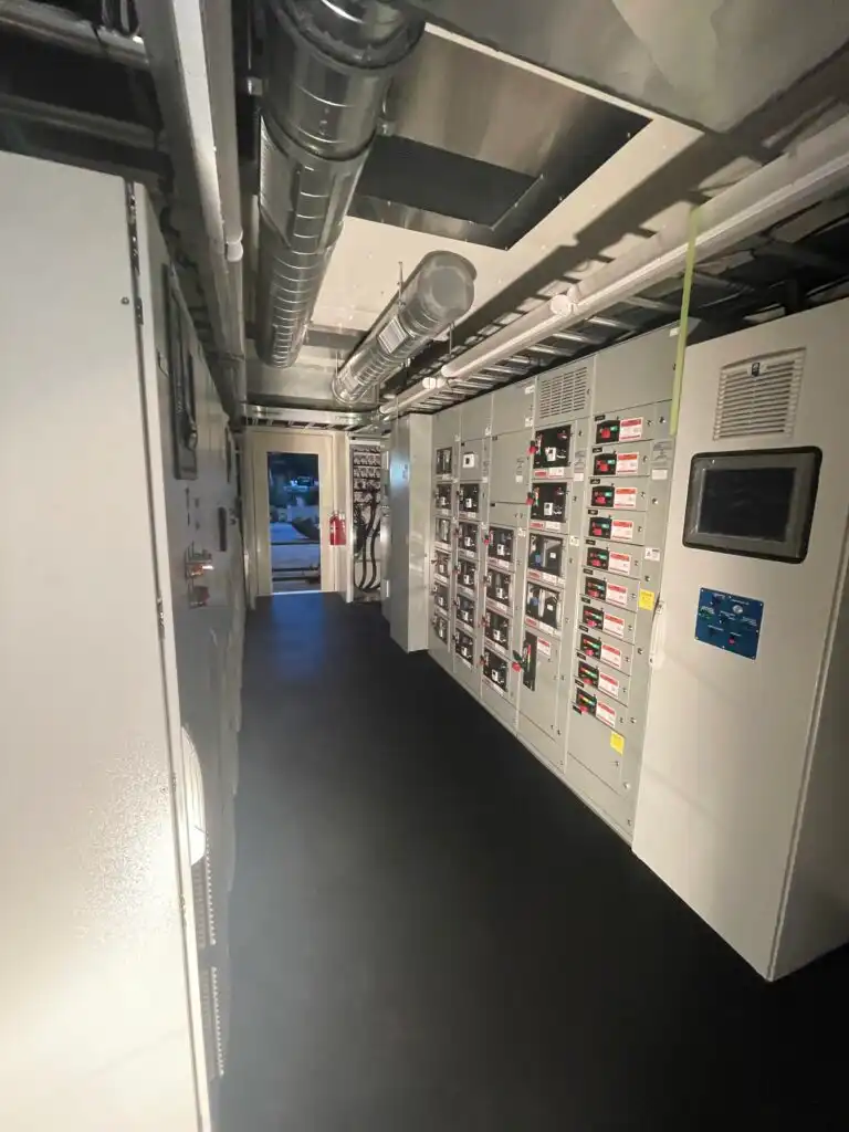 Industrial control room with electrical panels and control systems.