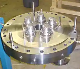 Metal industrial component with multiple protruding bolts, showcasing precision engineering.