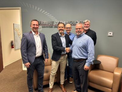 TTS team members and 2JCP Power Solutions representatives shaking hands after a partnership agreement.