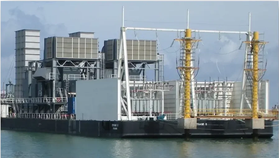 Industrial barge with power generation equipment docked at a port