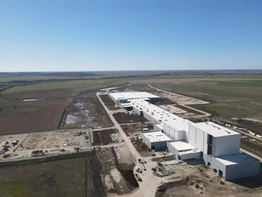 Aerial view of a large industrial facility under construction in a rural area.