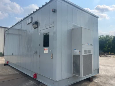 Exterior of a prefabricated electrical house (E-House) built for housing and protecting critical electrical equipment, featuring a high voltage warning on the door and an air conditioning unit for temperature control.