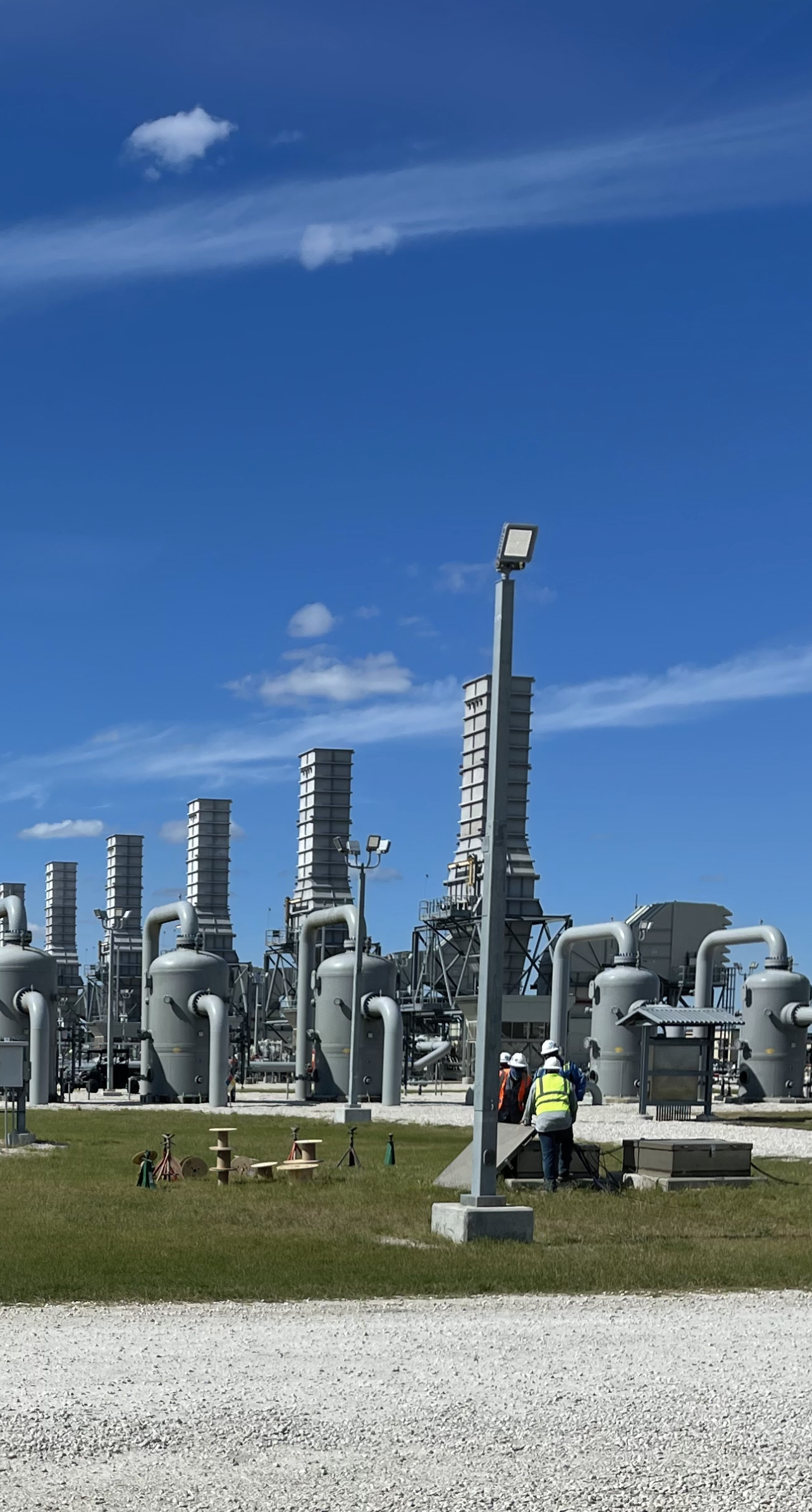 Natural gas plant workers inspecting equipment outdoors
