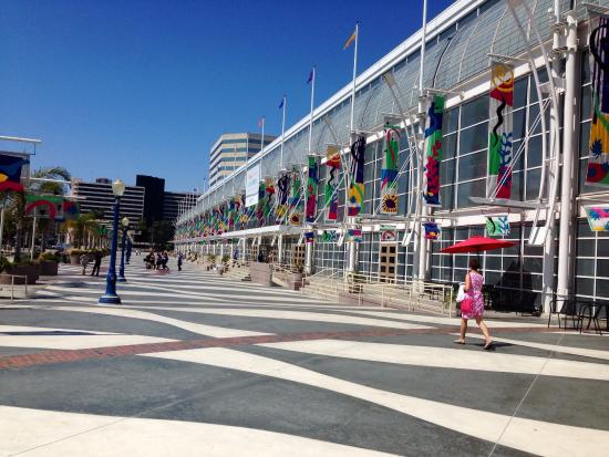 Woman walking outside convention center with flags