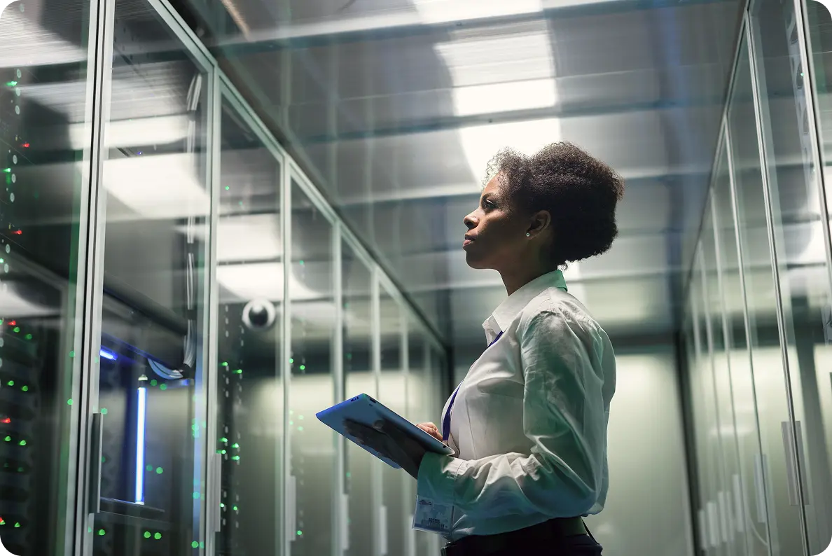 Woman inspecting servers with tablet in data center